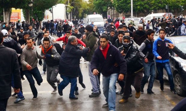 Protesters scramble in the streets of Tunis yesterday during nationwide protests at the assassination of opposition Popular Front leader Chokri Belaid.
