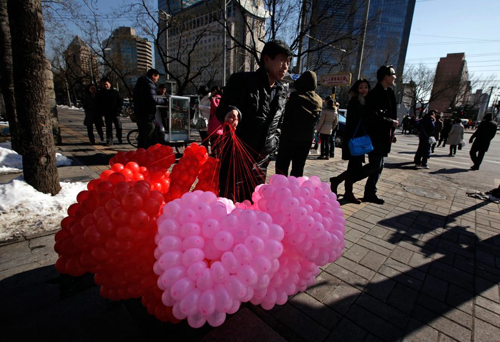 A vendor sells balloons tied in the shape of a heart for Valentine's Day in Beijing. 