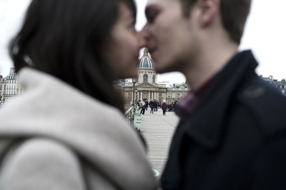 A couple kisses on the Pont des Arts during Valentine's day. (Photo:AFP)