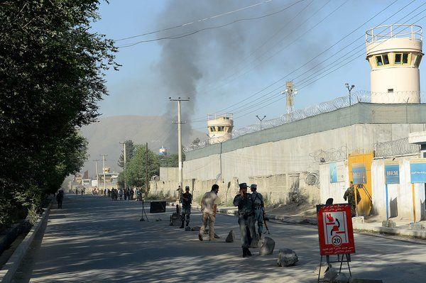 Afghan security forces stood guard as smoke rose from the entrance gate of the presidential palace in Kabul on Tuesday.