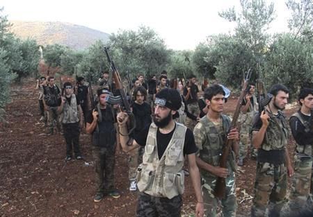 Free Syrian Army fighters, holding their weapons, stand during military training north of Idlib July 7, 2013. Picture taken July 7, 2013.