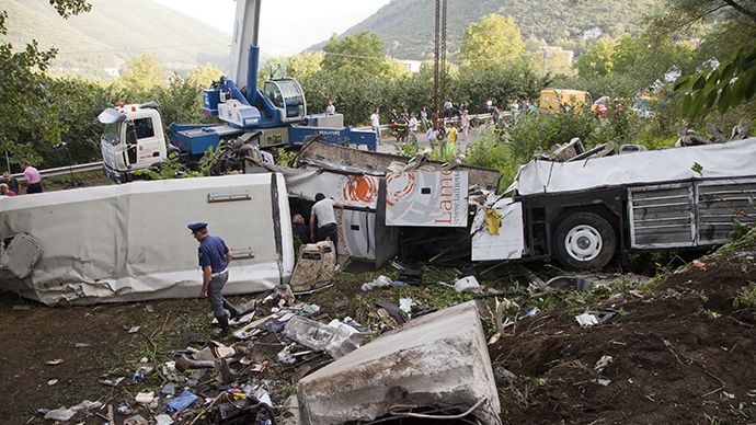 Police inspect remains of a bus crash on July 29, 2013 on the road between Monteforte Irpino and Baiano, southern Italy. (AFP Photo / Carlo Hermann)