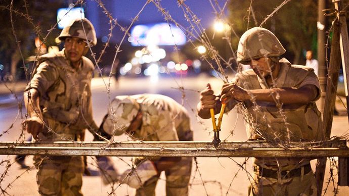 Egyptian army soldiers take out barbed wire that was surrounding the Supreme Constitutional Court in Cairo ahead of planned demonstrations on August 18, 2013. (AFP Photo / Virginie Nguyen Hoang)
