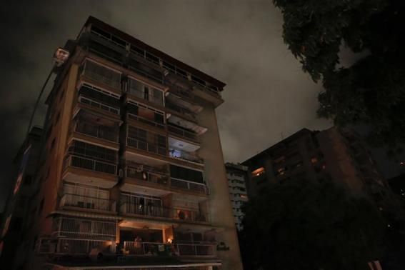 A man stands at the balcony of his apartment as he waits for the power to return after a blackout in Caracas December 2, 2013.@reuters