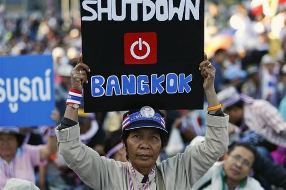 An anti-government protester joins others blocking the road at one of major intersections in central Bangkok January 13, 2014. 