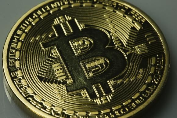 A mock Bitcoin is displayed on a table in an illustration picture taken in Berlin January 7, 2014.