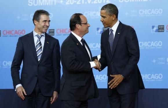 U.S. President Barack Obama (R) and NATO Secretary General Anders Fogh Rasmussen (L) welcome French President Francois Hollande to the NATO Summit in Chicago, May 20, 2012.