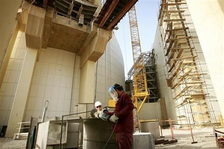 Workers work at the nuclear plant in the southwestern Iranian city of Bushehr June 22, 2005.