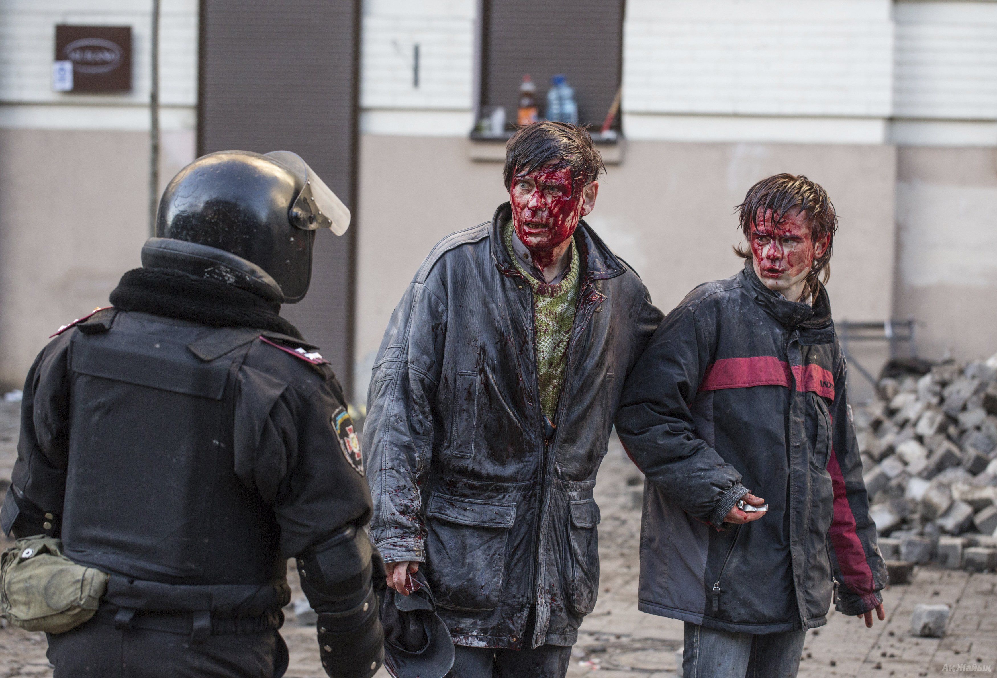 Wounded people are seen after clashes with riot police in central Kiev February 18, 2014. 