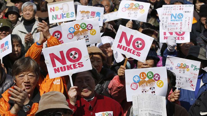 Anti-nuclear protesters hold banners saying 