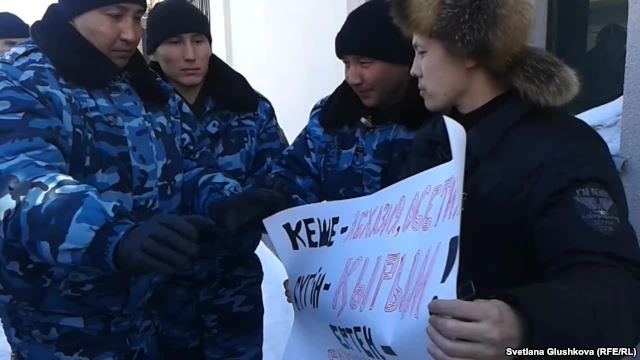 Kazakh police speak with Makhambet Abzhan (right) outside the Russian Embassy in Astana on March 3.