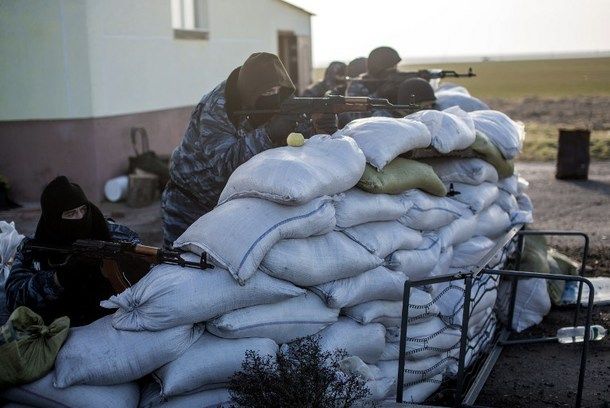 Armed pro-Russian servicemen stand guard at Chongar checkpoint blocking the entrance to Crimea on March 10, 2014