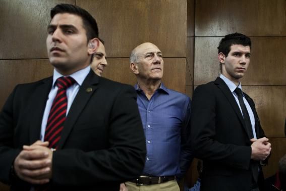 Former Israeli Prime Minister Ehud Olmert (2nd R) waits to hear his verdict at the Tel Aviv District Court March 31, 2014.