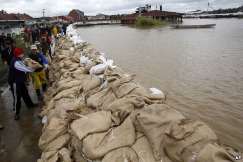 People build a dam made up of sandbags by the bank of the Sava river in Sremska Mitrovica, Serbia.