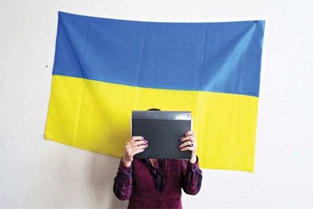 Antonina Melnykova, head of the district election commission in Luhansk Oblast’s Lysychansk, stands by a Ukrainian flag. She doesn’t show her face to avoid being identified by Kremlin-backed separatists. (Photo:kyivpost.com)