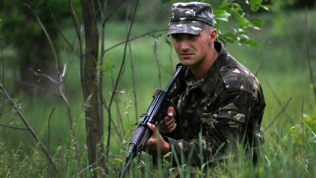 An Ukrainian soldier secures an area near the site where pro-Russian rebels killed thirteen Ukrainian servicemen in eastern Ukraine on Thursday. Fighting continues in Ukraine's east between pro-Russia insurgents and government forces days before a presidential election. (Yannis Behrakis/Reuters)