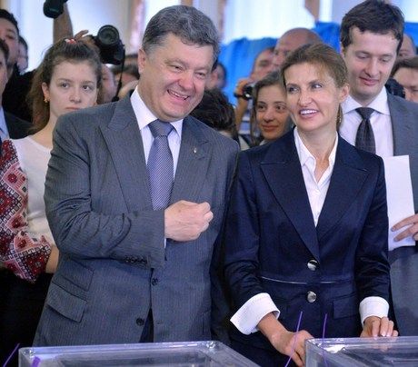 Ukrainian presidential candidate Petro Poroshenko crosses himself as he and his wife Marina cast their votes at a polling station in Kiev on May 25, 2014.