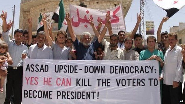 Protesters who oppose Syrian President Bashar Assad carry a banner during a demonstration at Kafr Nabil town in Idlib province, northern Syria ( 30 May 2014) But in rebel-held areas, people have dismissed the elections as a sham.