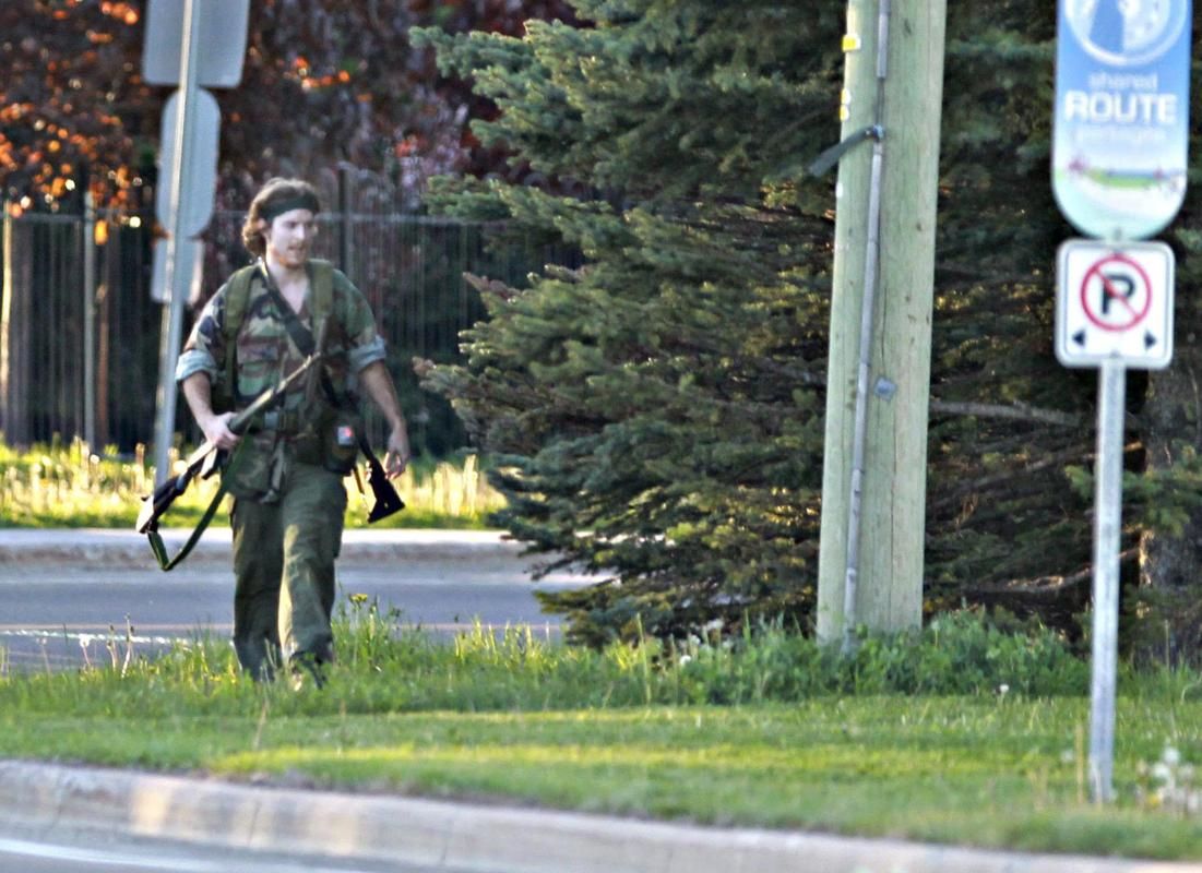 A heavily armed man that police have identified as Justin Bourque walks on Hildegard Drive in Moncton, New Brunswick, on Wednesday, June 4, 2014.