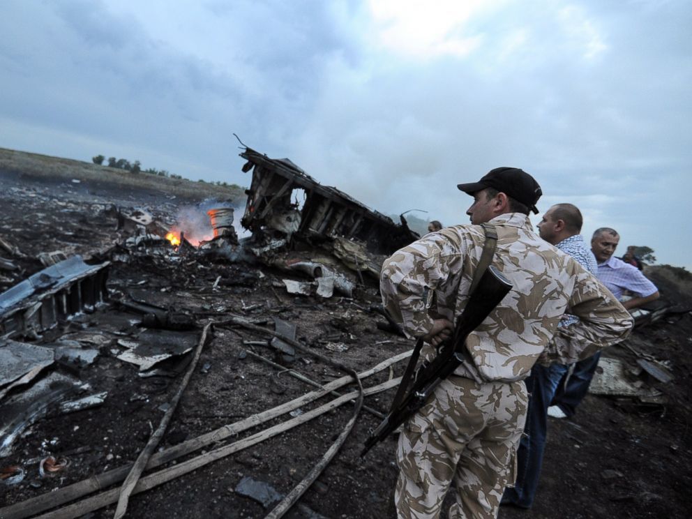 Men stand next to the wreckage of the Malaysian airliner that crashed near the town of Shaktarsk in rebel-held east Ukraine on July 17, 2014.