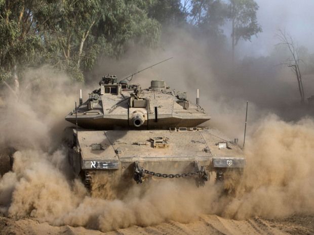 An Israeli Merkava tank rolls near Israel's border with the Gaza Strip Thursday.