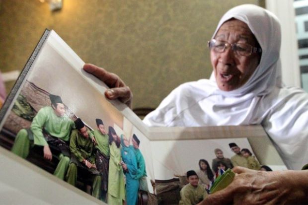 Jamillah showing the family photo album at her home. Pix by Zulazhar Sheblee/The Star