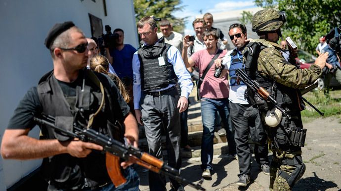 Chief of Monitors from the Organization for Security and Cooperation in Europe (OSCE) Alexander Hug walks with separatists at a railway station in the eastern Ukrainian town of Torez.(AFP Photo) 