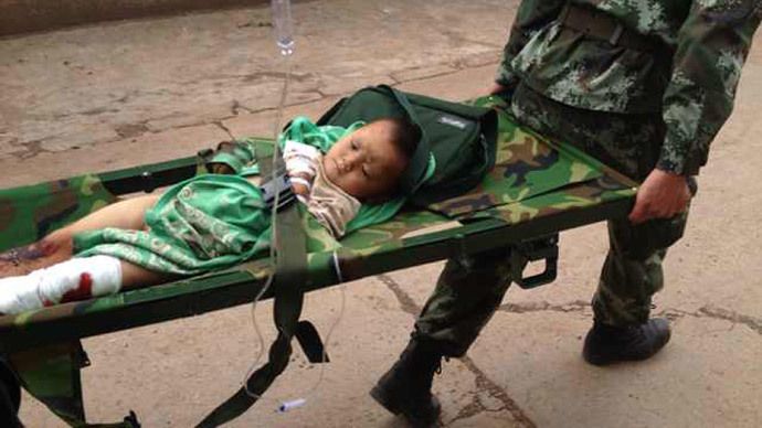 Rescuers carry an injuried child on a stretcher after a 6.1 magnitude earthquake hit the area in Ludian county in Zhaotong, southwest China's Yunnan province on August 3, 2014.(AFP Photo / China Out)