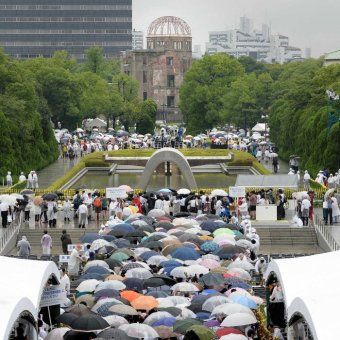 People gather at the foot of the Atomic Bomb Dome (background) at the Peace Memorial Park in Hiroshima.  (AFP)