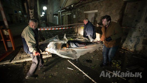 People carry the body of a victim killed by recent shelling near the Red Cross office in Donetsk, eastern Ukraine, October 2, 2014.