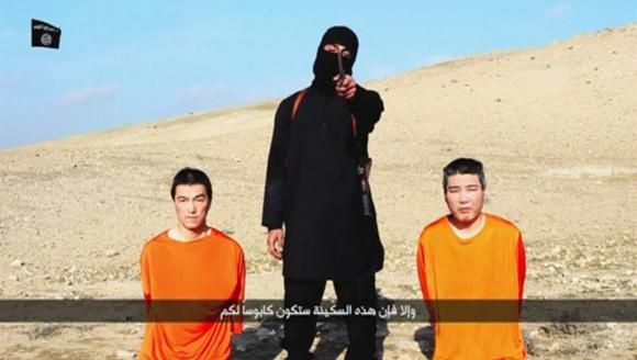 A masked person holding a knife speaks as he stands in between two kneeling men in this still image taken from an online video released by the militant Islamic State group on January 20, 2015. Reuters