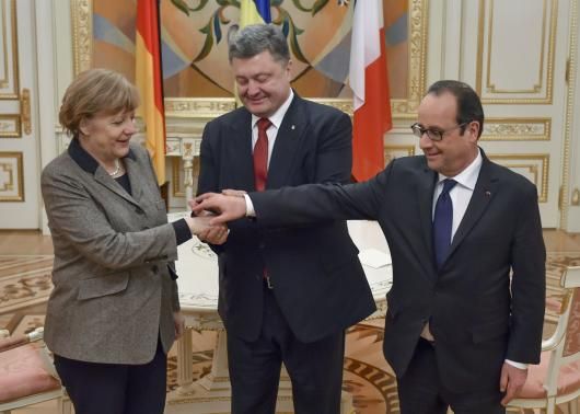 Ukraine's President Petro Poroshenko (C) shakes hands with German Chancellor Angela Merkel and French President Francois Hollande during their meeting in Kiev, February 5, 2015.