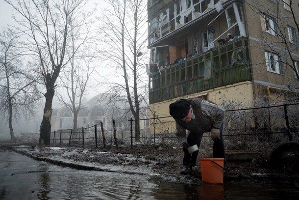 A resident collects water from a broken pipe in the eastern Ukrainian city of Donetsk on Feb. 15. Fighting dropped sharply but there was still sporadic shooting after a ceasefire came into force across east Ukraine, the first step in a fragile peace plan aimed at ending 10 months of conflict.