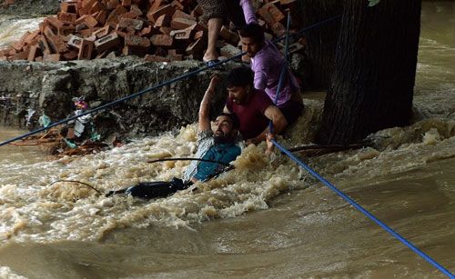 A man being rescued from teh storm. AFP PHOTO