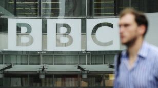 Лондондағы BBC кеңсесі алдынан өтіп бара жатқан адам. (Көрнекі сурет)
