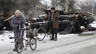 Донецкіге жақын Углегорск қаласында тұрғындар қираған әскери техникалардың қасынан өтіп барады. Шығыс Украина, 19 ақпан 2015 жыл.