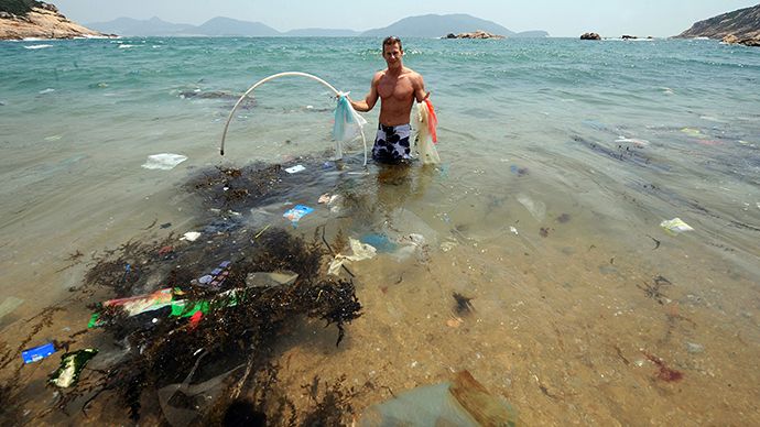 Волонтер собирает мусор в воде к югу от Гонконга. Фото AFP