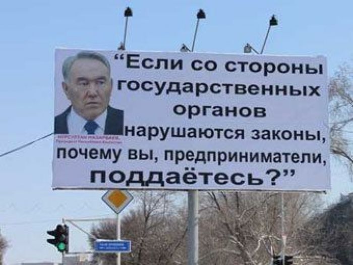 Woman beaten for photo of Nazarbayev billboard on ground
