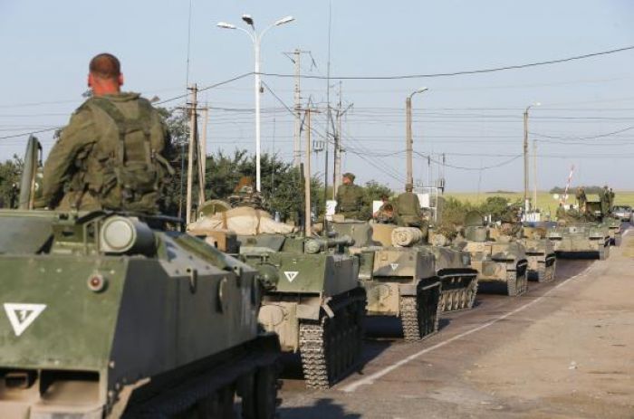 Russian aid convoy checked; military vehicles mass near Ukraine