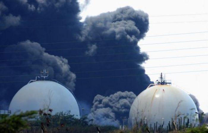 New tank burns at Venezuela refinery; death toll revised down