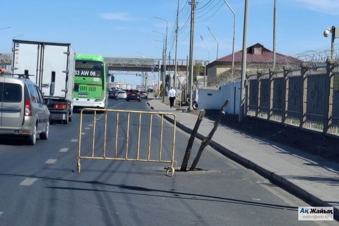 Атырауда жолдағы ашық құдық бұтақтармен белгіленген