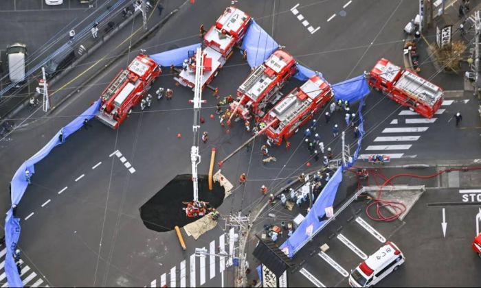 В Японии спасатели третий день пытаются вытащить водителя, застрявшего с фурой в гигантской яме
